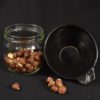 Entonnoir Noir posé à côté d'un bocal de noisettes